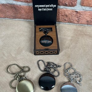 May include: A wooden box with a pocket watch inside, and two other pocket watches. The box has the text "every moment spent with you hope it lasts forever." The pocket watch inside the box has the text "daddy's girl."