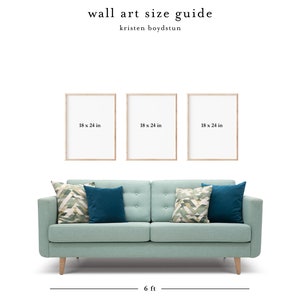 May include: Three 18 x 24 inch wood framed prints hanging above a light blue sofa with patterned throw pillows. The sofa is 6 feet wide.