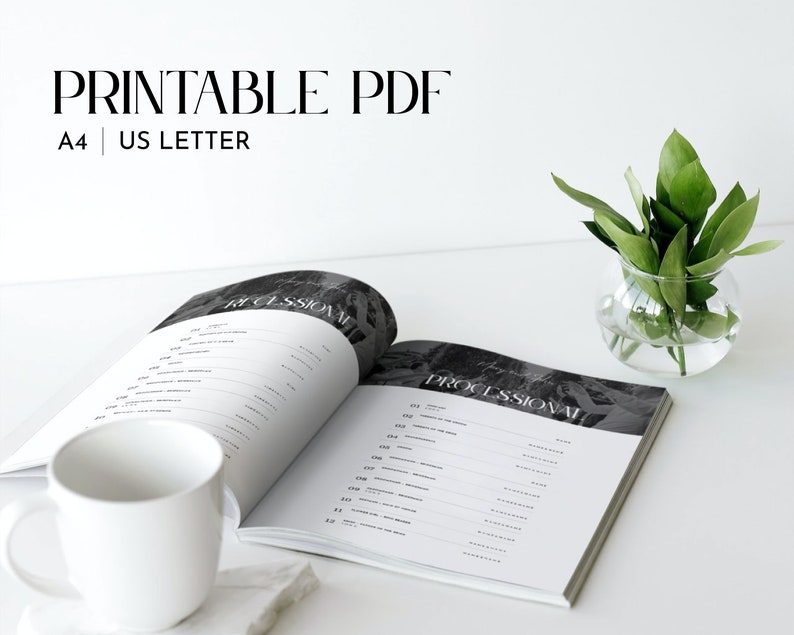 May include: An open book with the word "Processional" printed on the right page. The book is on a white surface with a white mug and a small glass vase with green leaves.