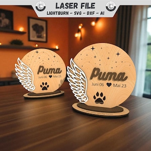 Könnte beinhalten: Gedenktafel aus Holz mit dem Namen "Puma", einem Pfotenabdruck und Daten, mit Engelsflügeln. Die Tafel ist kreisförmig, mit Sternen, und steht auf einem Holzsockel. Der Text "LASER FILE" steht oben.