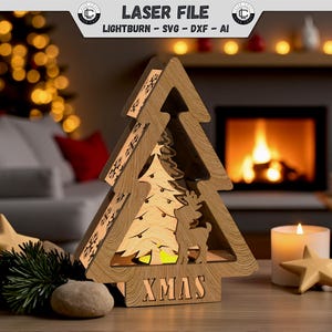 Könnte beinhalten: Eine lasergeschnittene Weihnachtsbaum-Dekoration aus Holz mit einem Rentier- und Baumdesign. Das Wort "XMAS" befindet sich am Sockel. Eine brennende Kerze und sternförmige Dekorationen befinden sich in der Nähe. Der Hintergrund umfasst einen Kamin und Weihnachtsbeleuchtung.