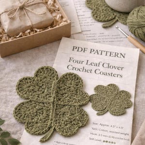 May include: A handmade crochet pattern for four-leaf clover coasters. The image shows finished coasters, a crochet hook, yarn, and a cup of coffee. The coasters are approximately 4.5 inches by 4.5 inches.