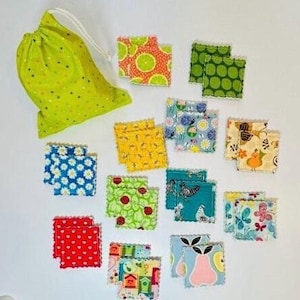 May include: A set of 12 fabric squares with various colorful patterns, including floral, geometric, and animal prints. The squares are packaged in a green drawstring bag with white polka dots.