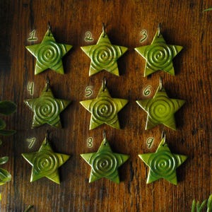 Puede incluir: Nueve estrellas de cer&aacute;mica verde en forma de estrella con un patr&oacute;n de espiral. Cada estrella tiene un agujero en la parte superior para colgar.