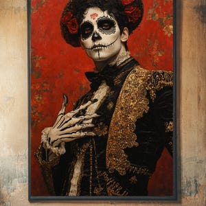 May include: A framed portrait of a person in Day of the Dead attire. The person wears a black suit with gold trim, a black bow tie, and a hat adorned with red roses. The face is painted with a skull design against a red floral background.