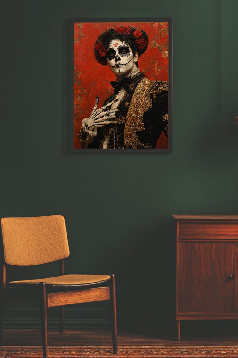 May include: Framed artwork depicting a person in Day of the Dead attire. The person wears a black and gold jacket, a floral hat, and skull makeup. The background is red with floral patterns. A wooden chair and cabinet are in the foreground.