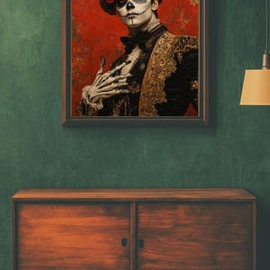 May include: A framed portrait depicting a person in Day of the Dead makeup and attire. The person wears a black jacket with gold detailing, a bow tie, and a floral headpiece. The background is red with floral patterns.