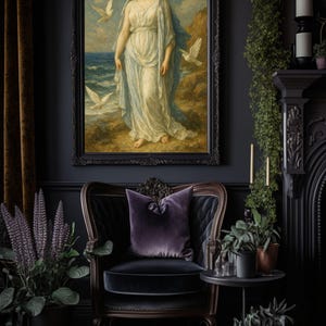 May include: A framed painting of a woman in a white dress standing on a beach with doves flying around her. The painting is set against a dark gray wall with a black velvet armchair and a side table with potted plants.