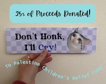 Peut inclure: Une pancarte à carreaux violets et blancs avec le texte "Don't Honk, I'll Cry!" et une image de mème de chat pleurant. La pancarte indique "25% of Proceeds Donated!" en haut et "To Palestine Children's Relief Fund" en bas.