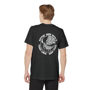 May include: A dark heather grey t-shirt with a white graphic of a fish and a crab in a circle. The text around the circle reads "Gettin' Jiggy With It Tight Lines Good Times".