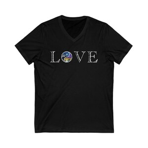 May include: Black V-neck t-shirt with the word "LOVE" in white, distressed lettering. The "O" in "LOVE" features a circular design with a landscape scene in shades of blue, purple, and yellow.