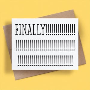 以下が含まれることがあります： 黒い文字で「FINALLY」と書かれ、その後に3列の黒い感嘆符が並ぶ白い長方形のグリーティングカード。カードは茶色の封筒の上に置かれています。デザインはカードの中央に配置され、鮮明な黒い文字で構成されています。