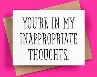 May include: A white rectangular greeting card with black text that reads YOU'RE IN MY INAPPROPRIATE THOUGHTS. The card is positioned on top of a brown paper envelope. The text is centered and written in a clean, sans-serif, uppercase font.