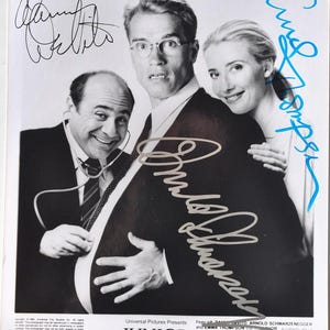 Może przedstawiać: Czarno-białe zdjęcie promocyjne filmu "Junior" z Arnoldem Schwarzeneggerem, Dannym DeVito i Emmą Thompson. Zdjęcie zawiera podpisy i tytuł filmu.