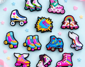 May include: A collection of twelve colorful roller skate charms featuring various designs including winged skates, rainbow motifs, and lightning bolt patterns in shades of pink, blue, yellow, and white with black outlines for shoe decoration.