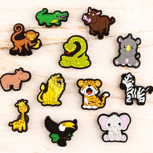 May include: A collection of colorful animal-shaped charms, including a monkey, alligator, snake, rhino, hippo, lion, tiger, zebra, giraffe, toucan, warthog, and elephant. Each charm has a black border and is set against a light wood-grain background.