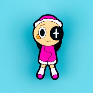 May include: A cartoon character pin featuring a round head with a white hat, one white eye, and one black eye with a white plus sign. The character wears a bright pink coat with white trim, white socks, and pink shoes against a solid blue background.