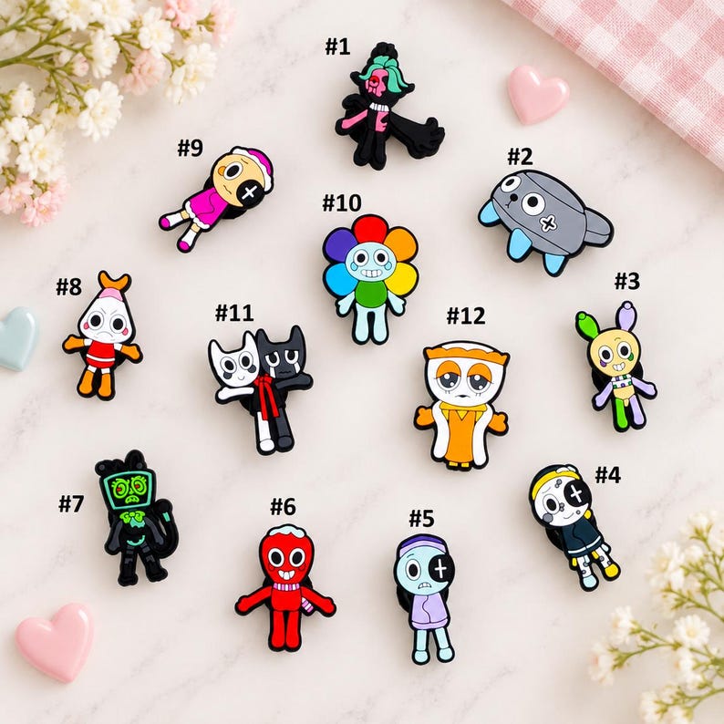 May include: A collection of twelve colorful cartoon-style shoe charms featuring various characters, including a rainbow flower, a grey creature, a red figure, and several humanoid designs, each labeled with a number from one to twelve.