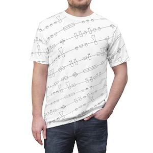 May include: White t-shirt with a black and white pattern of various shapes and lines. The pattern is repeated throughout the shirt.