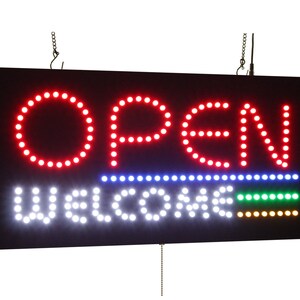 May include: Red LED sign with the word "OPEN" in large letters and "WELCOME" in smaller letters below. The sign has a black frame and is hanging from two chains.
