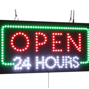 Pode incluir: Uma placa LED preta com borda verde, exibindo as palavras "ABERTO 24 HORAS" em luzes vermelhas e brancas.