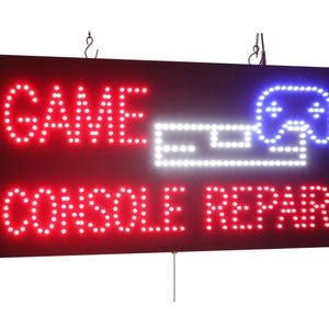 Puede incluir: Señal LED roja y blanca con el texto "GAME CONSOLE REPAIR" y una silueta blanca de un mando de videojuego.
