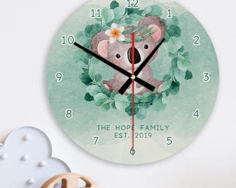 May include: A green and white watercolour clock featuring a koala bear design. The clock face has black numbers and hands. The text "THE HOPE FAMILY EST. 2019" is printed below the koala.