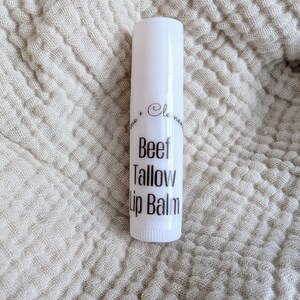Puede incluir: Tubo blanco de b&aacute;lsamo labial con texto negro que dice "Beef Tallow Lip Balm".