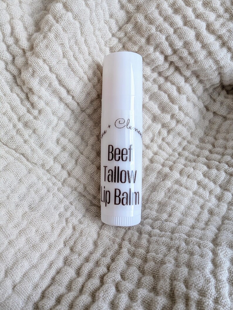 Puede incluir: Tubo blanco de b&aacute;lsamo labial con texto negro que dice "Beef Tallow Lip Balm".