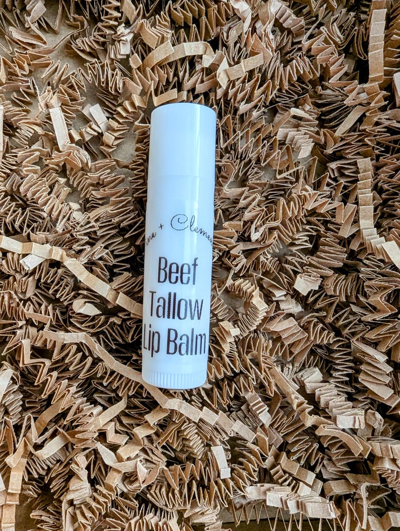 Puede incluir: Tubo blanco de b&aacute;lsamo labial con texto negro que dice "Beef Tallow Lip Balm".