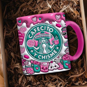 Puede incluir: Una taza de café de cerámica rosa y blanca con las palabras "Cafecito y Chisme" en un diseño verde y blanco. La taza tiene un asa rosa y está decorada con corazones e ilustraciones temáticas de café. La taza se presenta en una caja marrón.
