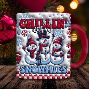 May include: White ceramic mug with a red handle featuring three snowmen wearing hats and scarves. The mug has the text "Chillin' with my Snowmies" in red and blue, with snowflakes and candy cane accents.