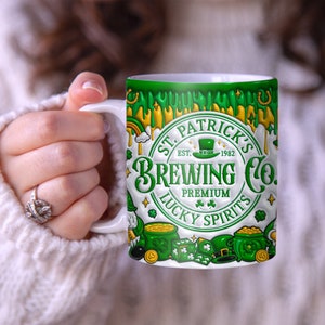May include: White ceramic mug with a green, gold, and white design. The design features a circle with the text "St. Patrick's Brewing Co. Est. 1982 Premium Lucky Spirits". The mug is decorated with shamrocks, gold coins, and a leprechaun hat.