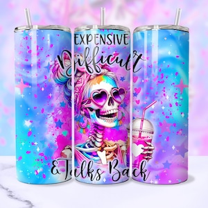 May include: A pink, blue and white stainless steel tumbler with a skull design and the text "Expensive, Difficult & Talks Back".
