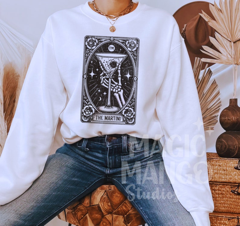 May include: White sweatshirt with a black and white illustration of a tarot card with the text "The Martini" and "TM" on the card.