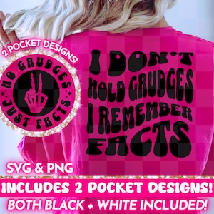 Op de afbeelding: Roze T-shirt met de tekst "I don't hold grudges I remember facts" in zwarte, retro-stijl letters. Een kleiner cirkelvormig ontwerp aan de linkerkant van het shirt zegt "No grudges just facts" met een vredesteken en een skelethand.