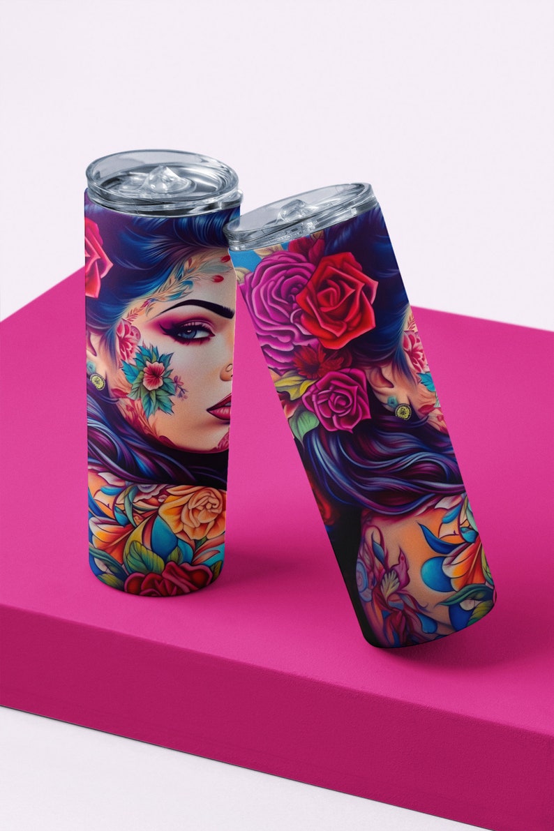 Pu&ograve; includere: Due bicchieri in acciaio inossidabile con un design colorato che presenta una donna con fiori e tatuaggi. Il design &egrave; vibrante e colorato con sfumature di rosa, blu, giallo e verde.