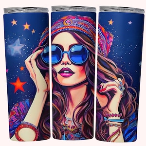 May include: A stainless steel tumbler with a colorful illustration of a woman wearing a headband, sunglasses, and jewelry. The background is a dark blue with white stars.