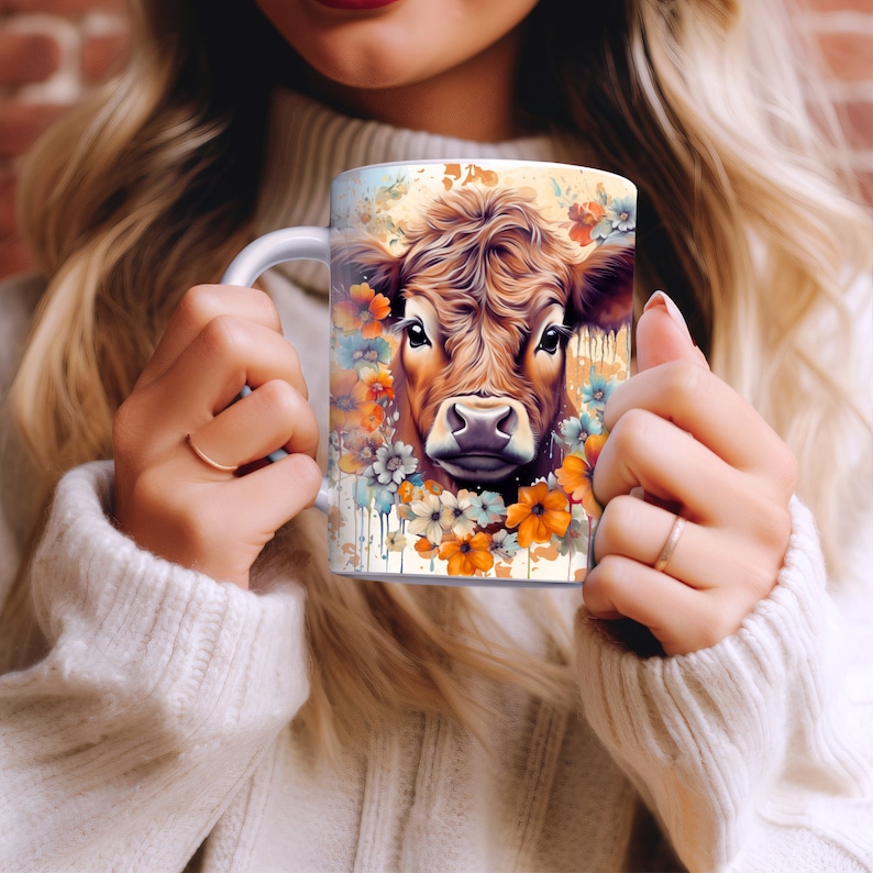 May include: White ceramic mug with a brown and white cow face illustration surrounded by colorful flowers. The cow has a brown nose and brown eyes.