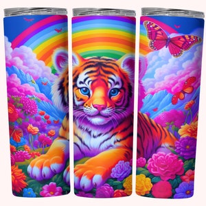 Puede incluir: Un vaso de acero inoxidable colorido con un arcoíris, nubes y un cachorro de tigre rodeado de flores. El cachorro de tigre tiene ojos azules y está acostado. Hay mariposas volando alrededor del cachorro de tigre.