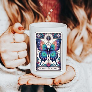 May include: White ceramic mug with a colorful butterfly illustration and the text "The Antisocial Butterfly".