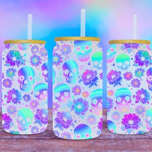 May include: Three white stainless steel tumblers with lids and straws. The tumblers are decorated with a holographic pattern of skulls and flowers in shades of pink, purple, and blue.