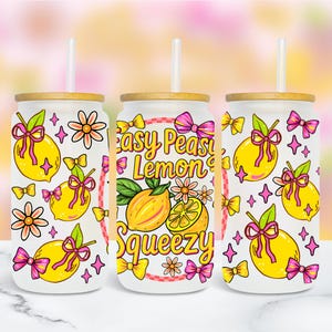 May include: Three glass tumblers with bamboo lids and straws. Each tumbler features a lemon design with pink bows, flowers, and the text "Easy Peasy Lemon Squeezy". The design is in a cartoon style.