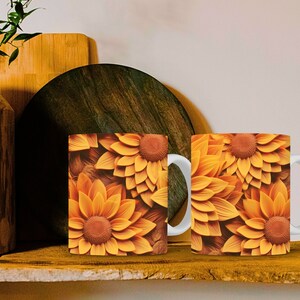 K&ouml;nnte beinhalten: Zwei wei&szlig;e Keramikbecher mit einem Sonnenblumenmuster. Die Becher haben einen wei&szlig;en Henkel und sind mit einem Nahaufnahmebild von gelben und orangefarbenen Sonnenblumen verziert.