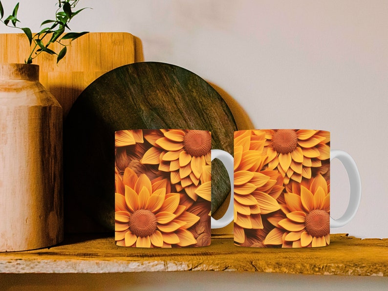 K&ouml;nnte beinhalten: Zwei wei&szlig;e Keramikbecher mit einem Sonnenblumenmuster. Die Becher haben einen wei&szlig;en Henkel und sind mit einem Nahaufnahmebild von gelben und orangefarbenen Sonnenblumen verziert.