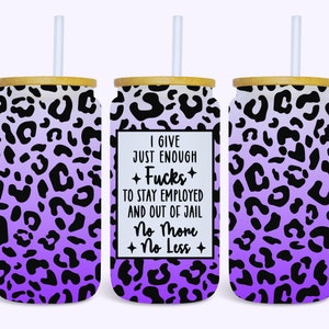 May include: Three glass tumblers with bamboo lids and white straws. The tumblers feature a purple and black leopard print design. One tumbler has the text "I give just enough f*cks to stay employed and out of jail. No more, no less."