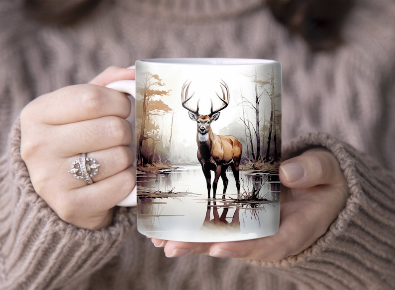 May include: White ceramic mug with a brown and white illustration of a deer standing in a lake with trees in the background.