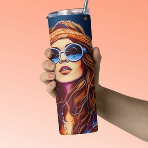 May include: A stainless steel tumbler with a colorful illustration of a woman with long brown hair wearing sunglasses and a headband. The tumbler has a straw.