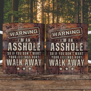 K&ouml;nnte beinhalten: Zwei wei&szlig;e Keramikbecher mit rustikalem braunem Hintergrund. Die Becher haben ein schwarzes Warnschild mit dem Text "WARNING I'M AN ASSHOLE SO IF YOU DON'T WANT YOUR FEELINGS HURT WALK AWAY" darauf gedruckt.