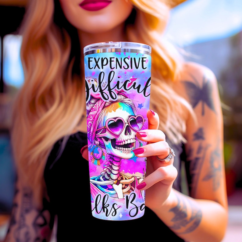 May include: A pink and blue stainless steel tumbler with a colorful skull design and the text "Expensive Difficult Looks Bad".